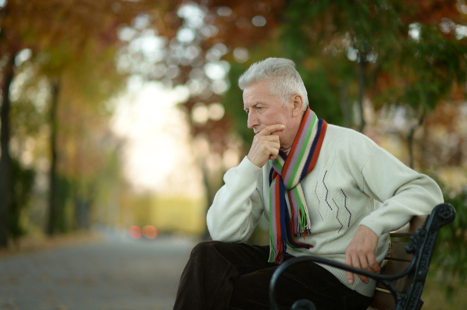 Man contemplating on park bench